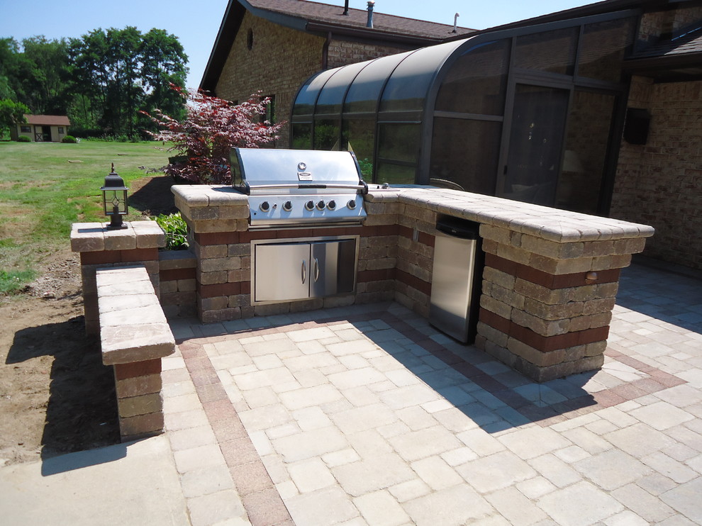 Idee per un grande patio o portico american style dietro casa con pavimentazioni in mattoni e una pergola