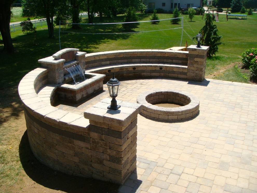 Imagen de patio de estilo americano de tamaño medio sin cubierta en patio trasero con adoquines de ladrillo y fuente