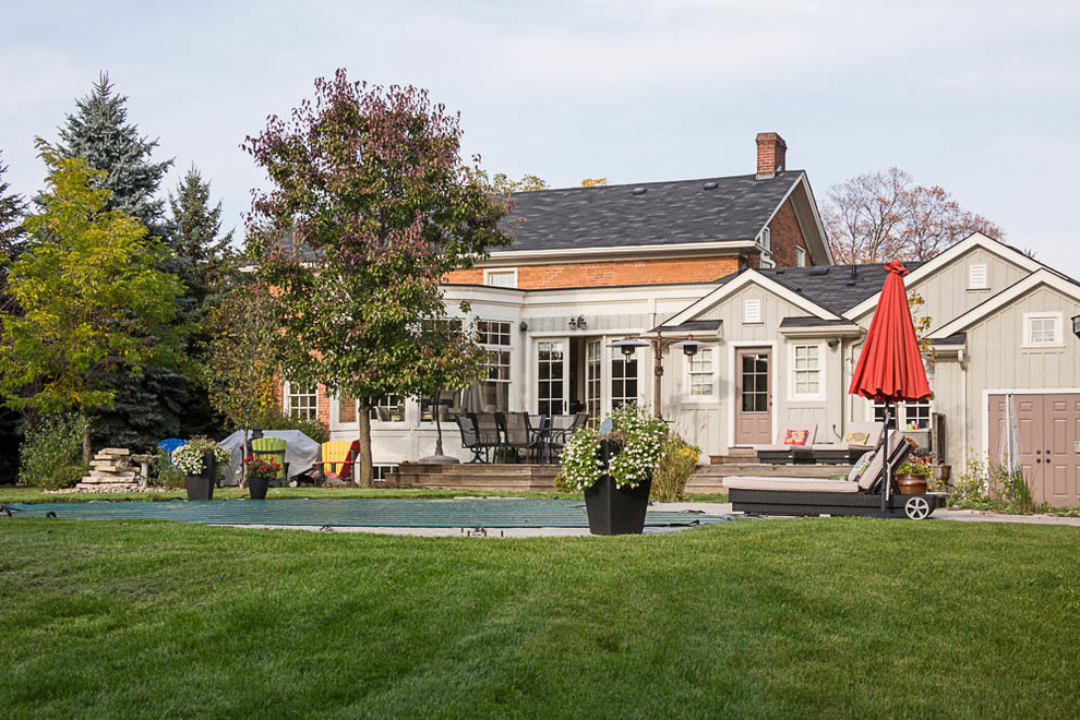 Modelo de patio de estilo de casa de campo de tamaño medio en patio trasero con jardín de macetas