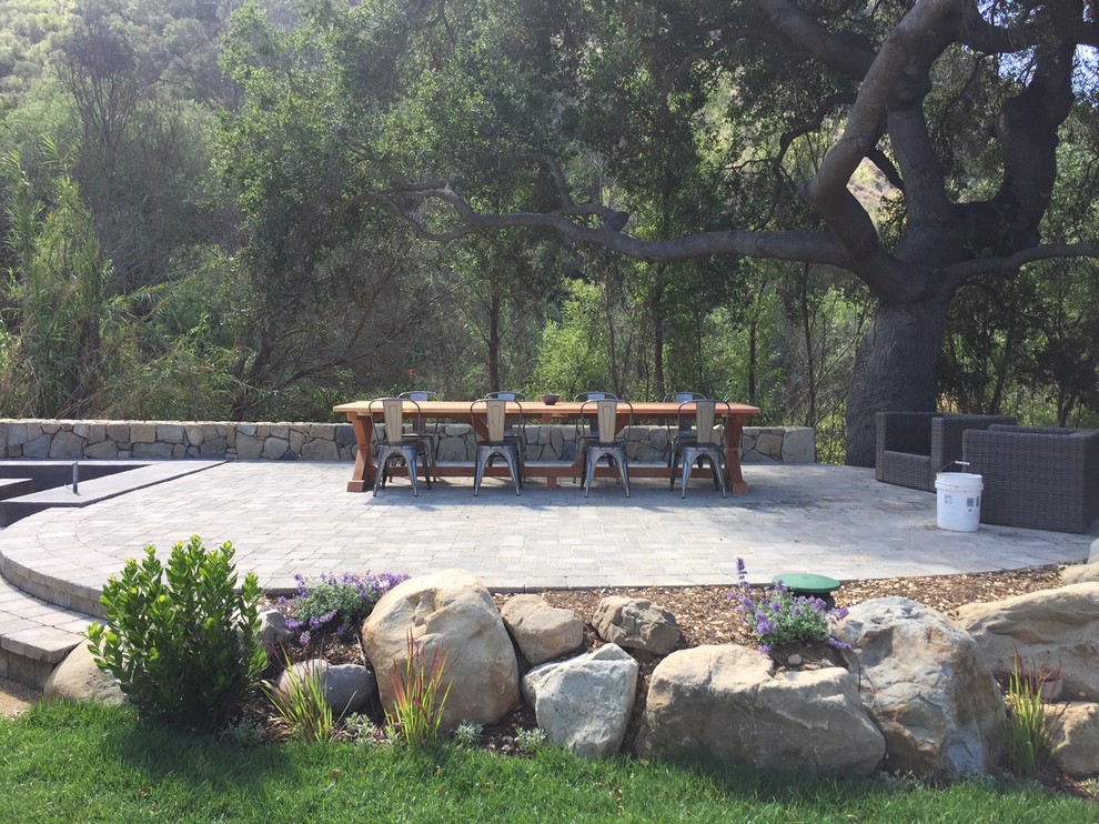 ロサンゼルスにある高級な広いカントリー風のおしゃれな裏庭のテラス (アウトドアキッチン、天然石敷き、日よけなし) の写真