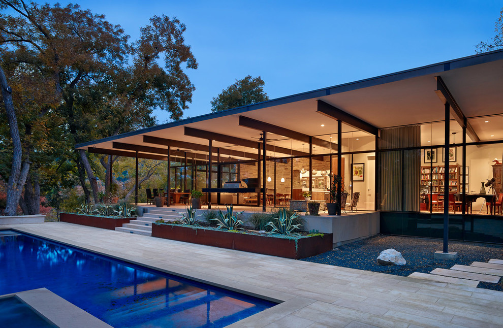 Пример оригинального дизайна: большой двор на заднем дворе в стиле модернизм с покрытием из каменной брусчатки и навесом