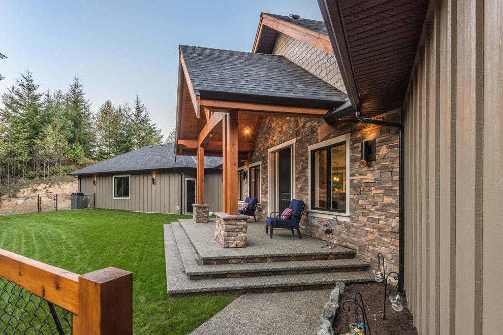 Immagine di un patio o portico stile rurale di medie dimensioni e dietro casa con lastre di cemento e un tetto a sbalzo