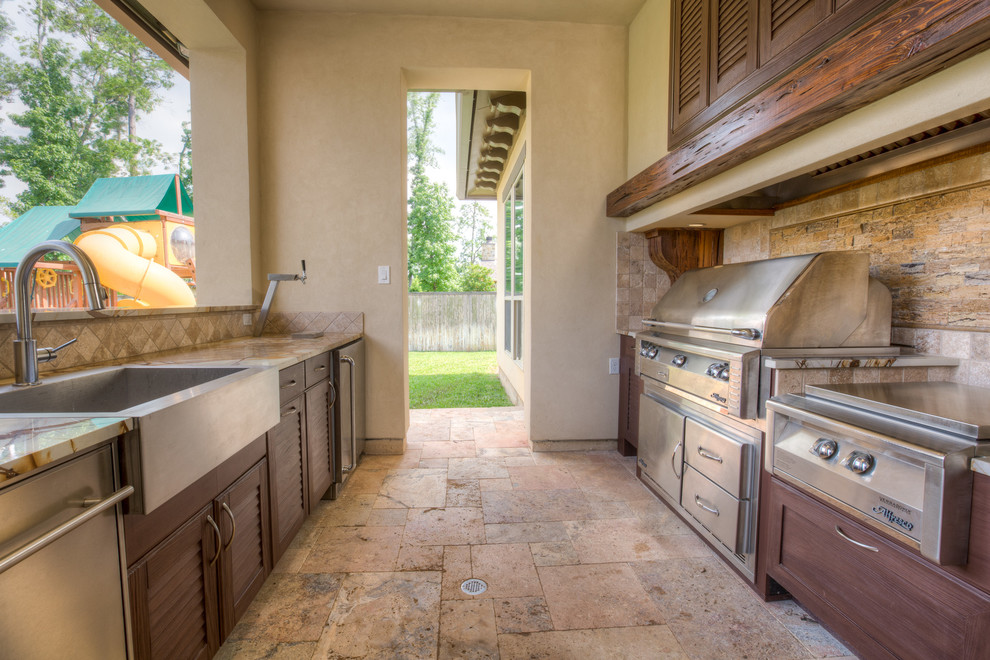 Example of a large trendy backyard stone patio kitchen design in Houston with a roof extension