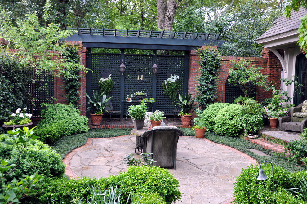 他の地域にある中くらいなトラディショナルスタイルのおしゃれな裏庭のテラス (天然石敷き、日よけなし、コンテナガーデン) の写真
