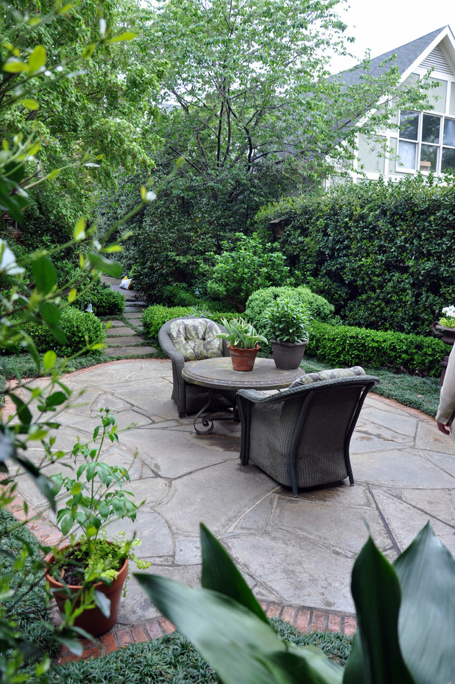 Diseño de patio clásico de tamaño medio sin cubierta en patio trasero con jardín de macetas y adoquines de piedra natural