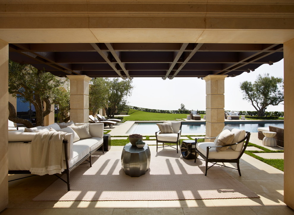 Inspiration for a large mediterranean side patio in Orange County with a fire feature and a roof extension.