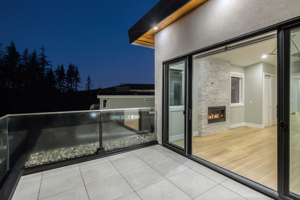 Inspiration for a medium sized contemporary back patio in Vancouver with an outdoor kitchen, concrete paving and a roof extension.