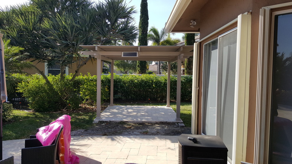 Example of a mid-sized classic backyard concrete paver patio design in Miami with a pergola