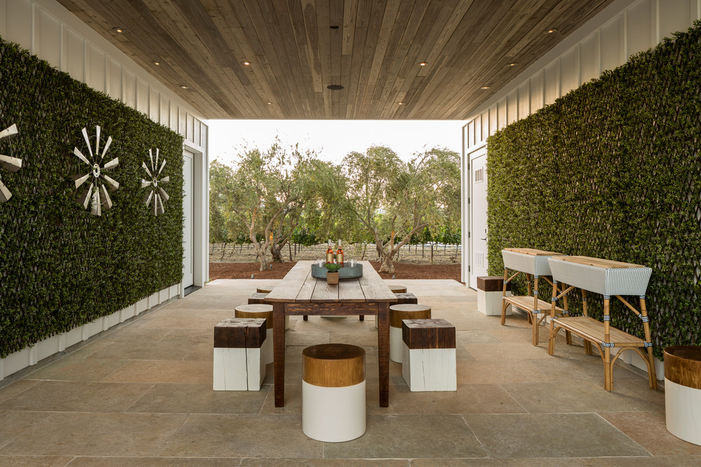 Cette photo montre un mur végétal de terrasse nature avec une cour, du carrelage et une extension de toiture.