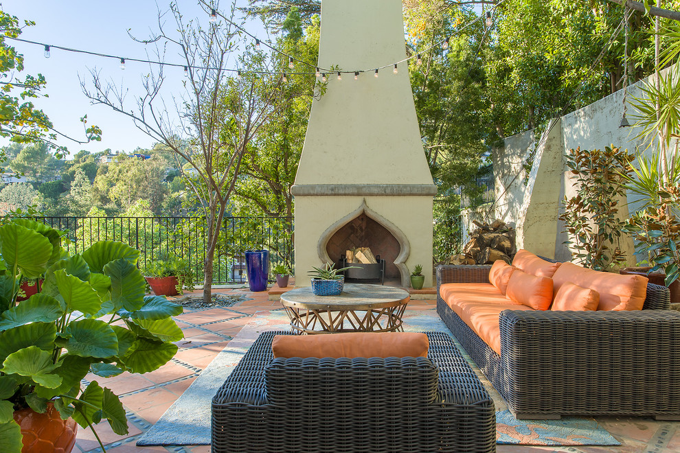 Источник вдохновения для домашнего уюта: двор в средиземноморском стиле с уличным камином без защиты от солнца