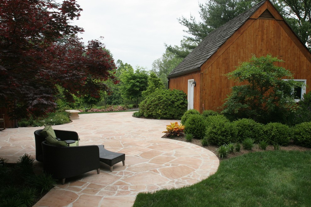 Idee per un grande patio o portico eclettico dietro casa con pavimentazioni in pietra naturale e nessuna copertura