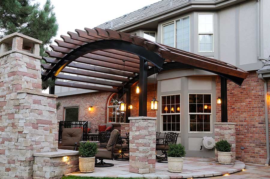 Transitional backyard stone patio photo in Denver with a pergola
