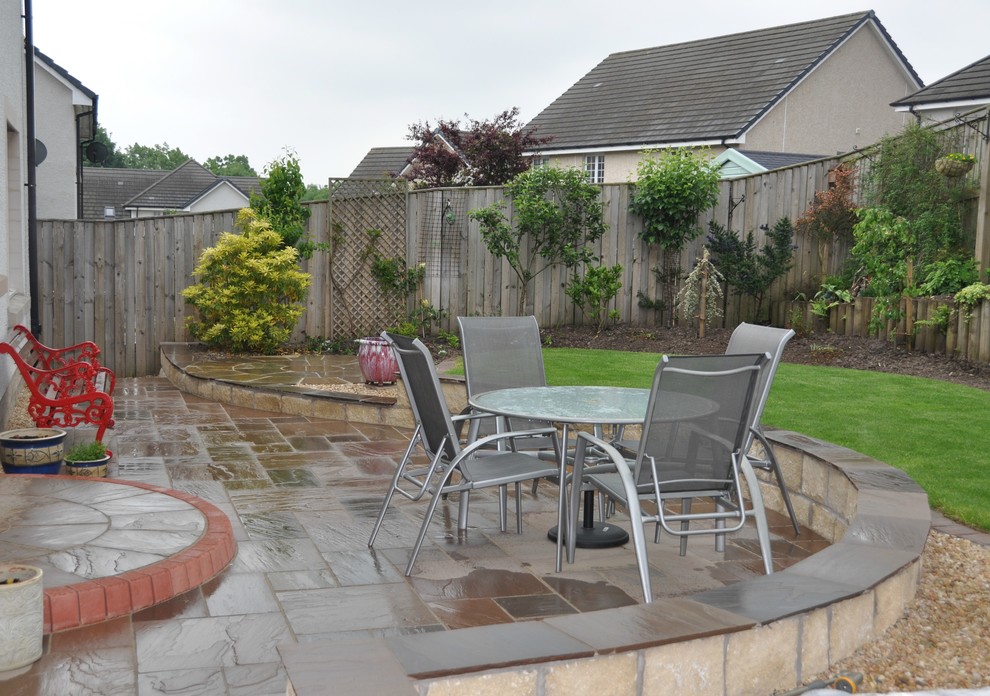 Curved sandstone patio provides a charming area for relaxing or