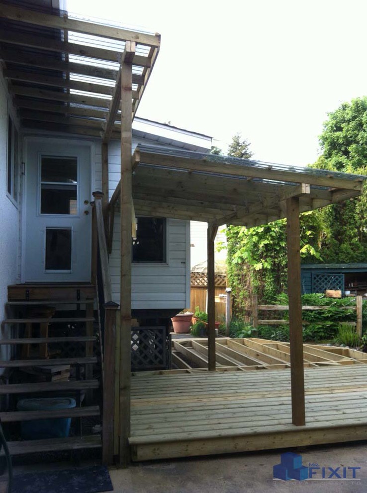 Small rustic back patio in Vancouver with concrete slabs and a roof extension.