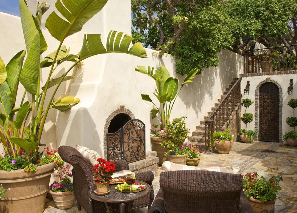 Tuscan side yard stone patio photo in San Diego with a fire pit and no cover
