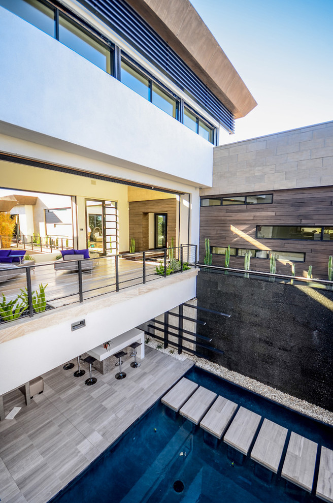 Photo of an expansive contemporary patio in Las Vegas with concrete slabs and a water feature.
