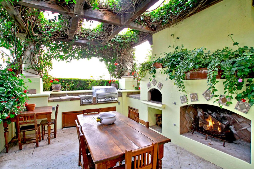 Foto de patio mediterráneo con pérgola y chimenea
