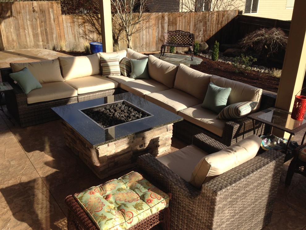 Mid-sized arts and crafts backyard stamped concrete patio photo in Portland with a fire pit and a roof extension