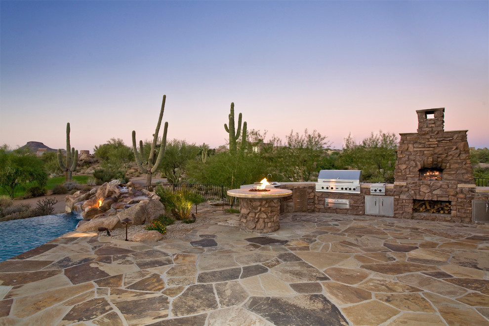 Unbedeckter Mediterraner Patio hinter dem Haus mit Natursteinplatten und Grillplatz in Phoenix