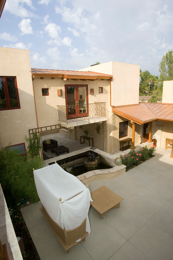 Пример оригинального дизайна: большой двор на заднем дворе в средиземноморском стиле с местом для костра, мощением тротуарной плиткой и навесом