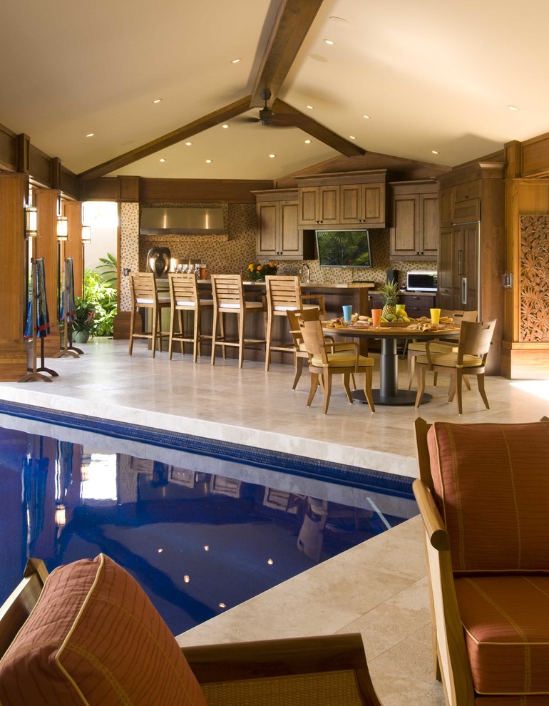 Large world-inspired back patio in Hawaii with an outdoor kitchen, tiled flooring and no cover.