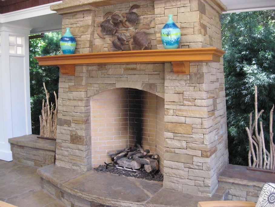 Photo of a coastal back patio in Other with a fireplace, natural stone paving and a roof extension.