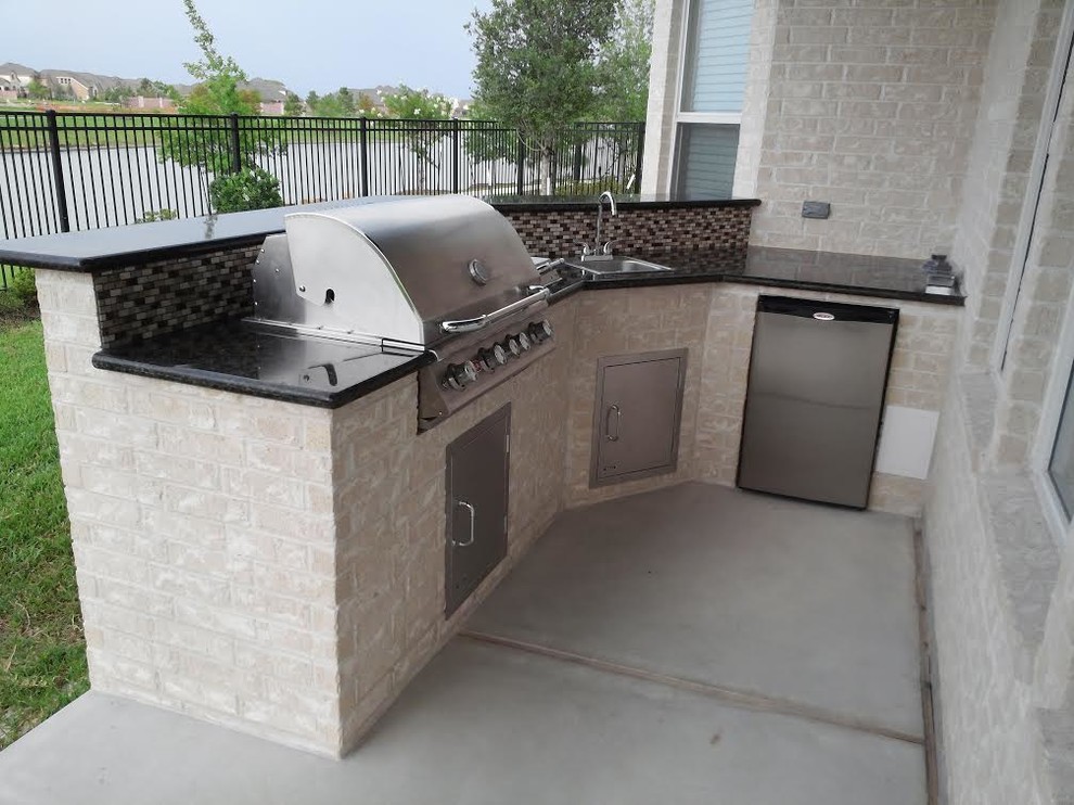 Design ideas for a small traditional back patio in Houston with an outdoor kitchen, concrete slabs and a roof extension.