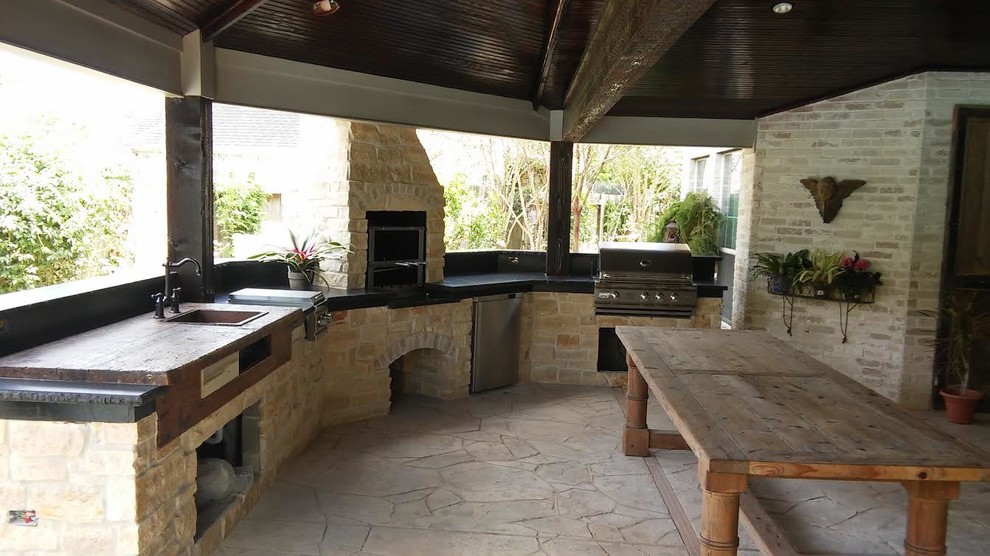 Idée de décoration pour une grande terrasse arrière tradition avec une cuisine d'été, des pavés en pierre naturelle et un gazebo ou pavillon.