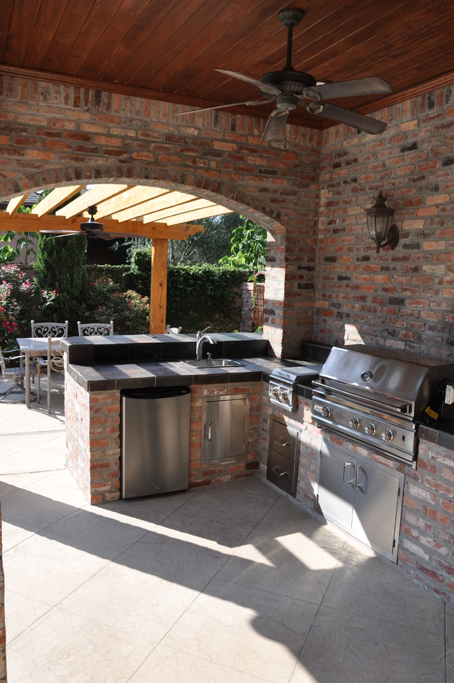 На фото: большой двор на заднем дворе в стиле рустика с летней кухней, покрытием из каменной брусчатки и навесом