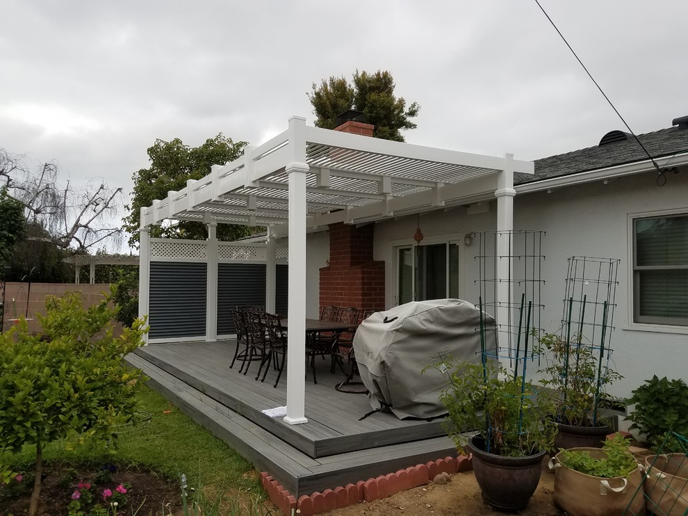 Example of a mid-sized classic backyard patio design in Los Angeles with decking and a pergola