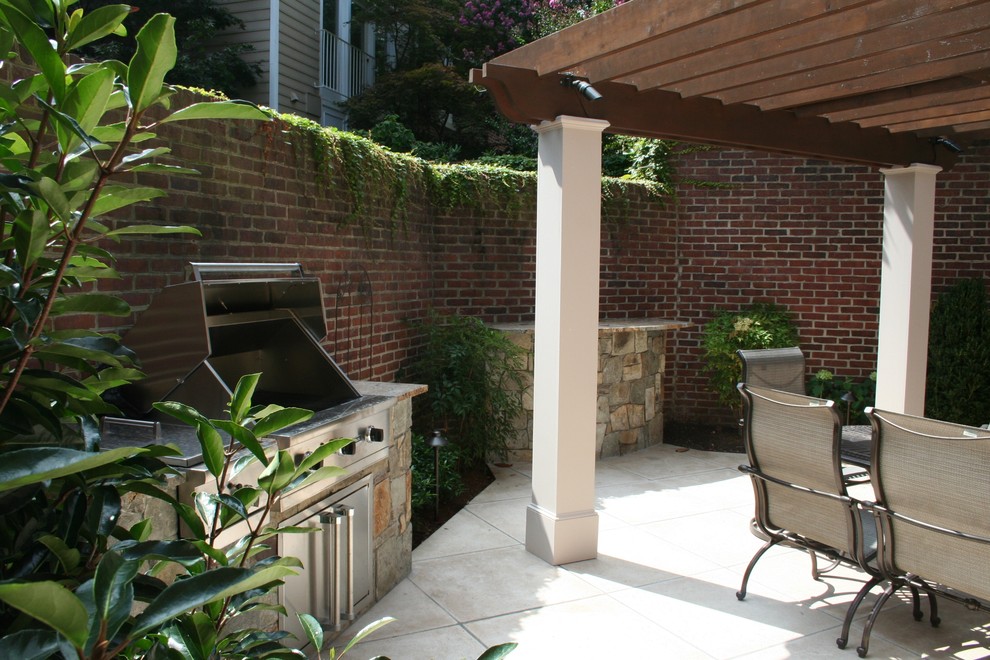 Foto di un piccolo patio o portico contemporaneo dietro casa con cemento stampato e una pergola
