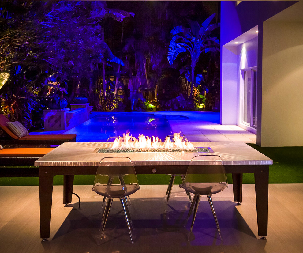 Large trendy backyard concrete paver patio photo in Miami with a fire pit and no cover