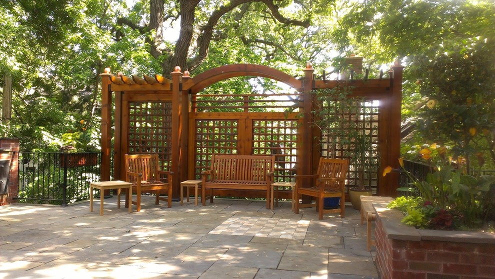 Design ideas for a large traditional back patio in Minneapolis with natural stone paving and no cover.