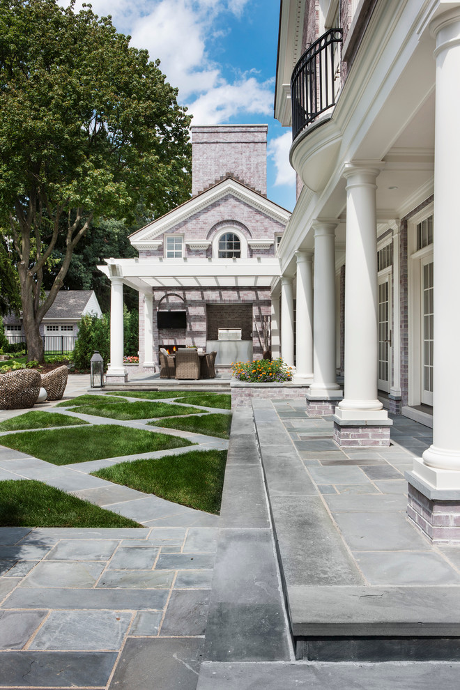 Foto di un ampio patio o portico classico dietro casa con piastrelle e una pergola