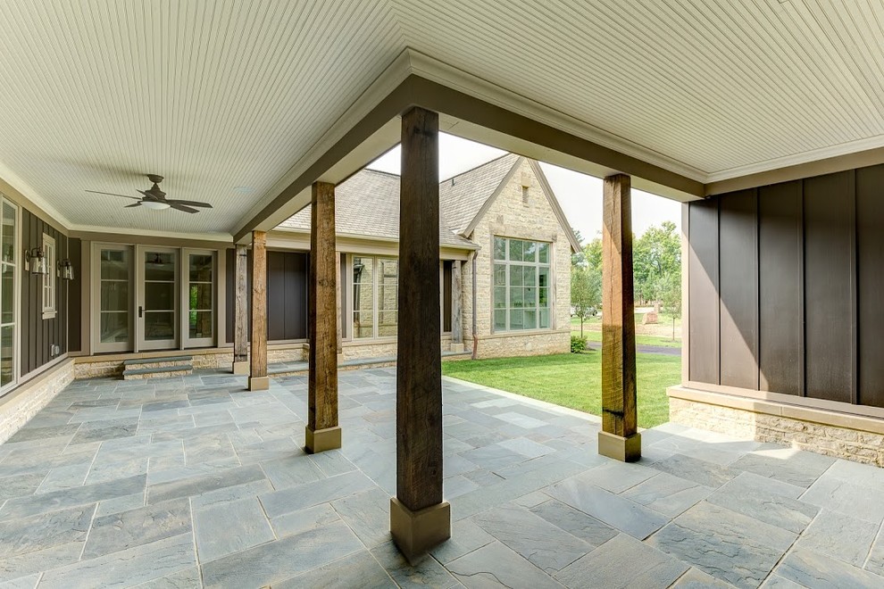 Источник вдохновения для домашнего уюта: огромный двор в стиле кантри с покрытием из каменной брусчатки и навесом