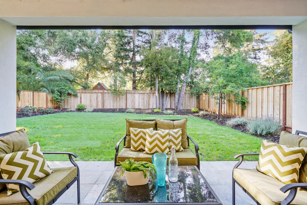 Esempio di un patio o portico minimalista di medie dimensioni e dietro casa con pavimentazioni in pietra naturale e un tetto a sbalzo