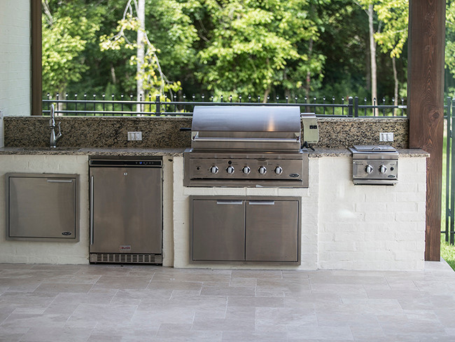 Medium sized mediterranean back patio in New Orleans with an outdoor kitchen, concrete paving and a roof extension.