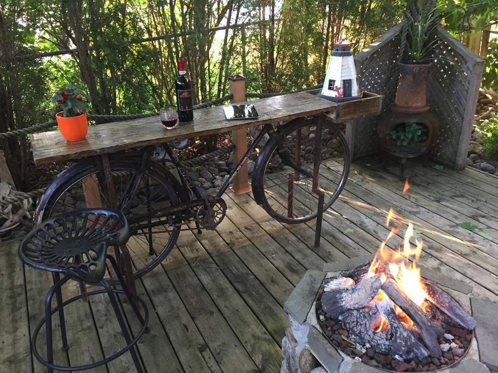 Small rustic back patio in Toronto with a fire feature and decking.