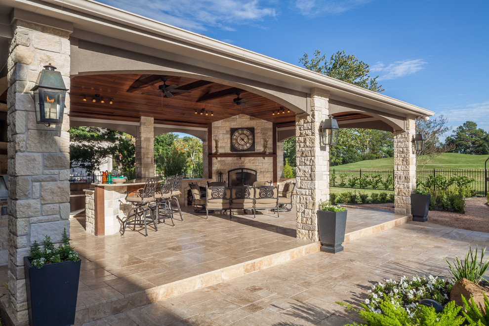 Idée de décoration pour une très grande terrasse arrière tradition avec une cuisine d'été, des pavés en pierre naturelle et une extension de toiture.