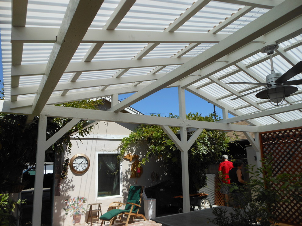 This is an example of a medium sized classic back patio in Orange County with concrete paving and a roof extension.