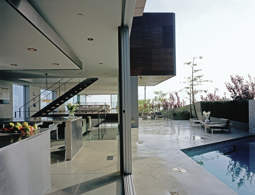 Expansive contemporary back patio in Los Angeles with no cover and concrete slabs.