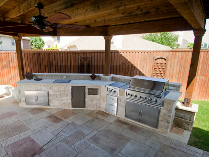 Ejemplo de patio tradicional de tamaño medio en patio trasero con cocina exterior, adoquines de piedra natural y cenador