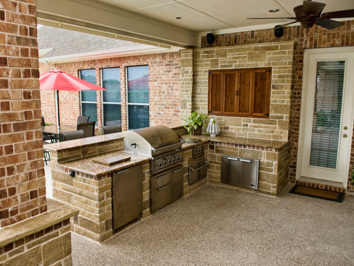Mid-sized elegant backyard stamped concrete patio photo in Dallas with a roof extension
