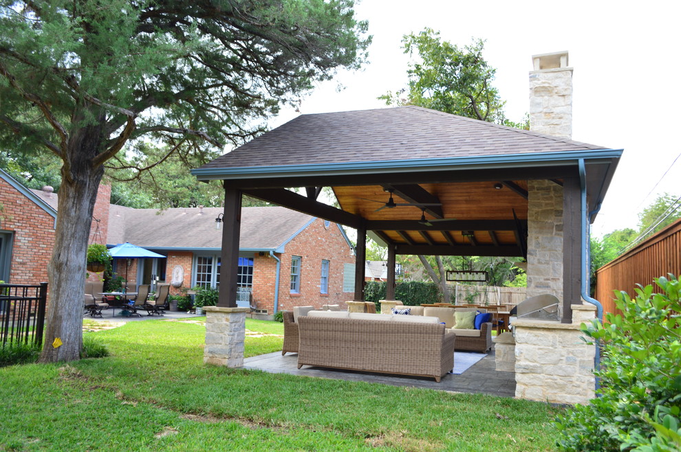 Expansive traditional back patio in Dallas with a fireplace.