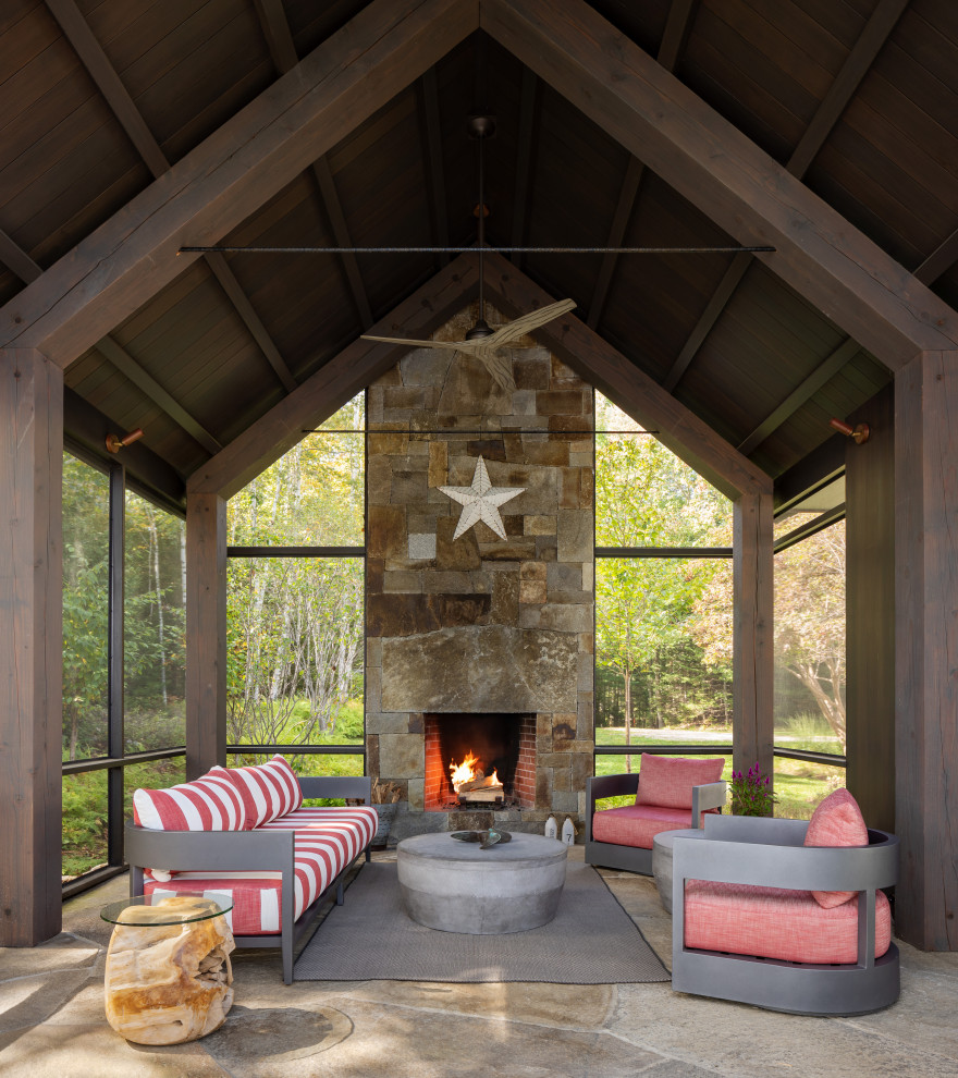 Inspiration for a beach style patio in Portland Maine with a fireplace, natural stone paving and a roof extension.