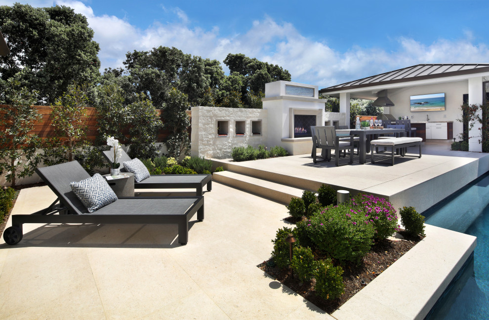 Imagen de patio contemporáneo grande en patio trasero con chimenea y adoquines de piedra natural