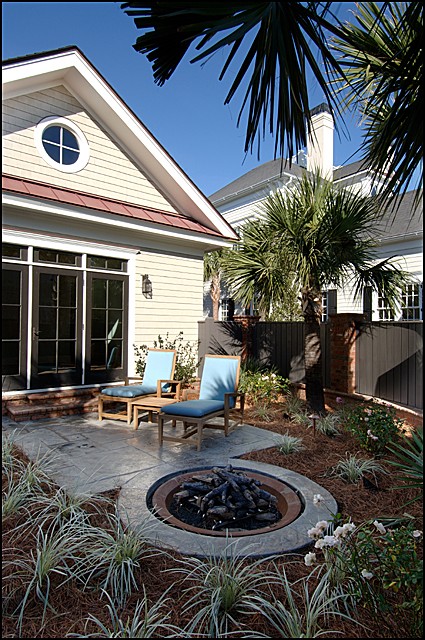 Aménagement d'une terrasse arrière éclectique de taille moyenne avec un foyer extérieur, du béton estampé et aucune couverture.