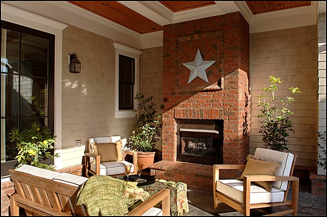 Immagine di un patio o portico boho chic di medie dimensioni e dietro casa con un focolare, pavimentazioni in pietra naturale e un tetto a sbalzo