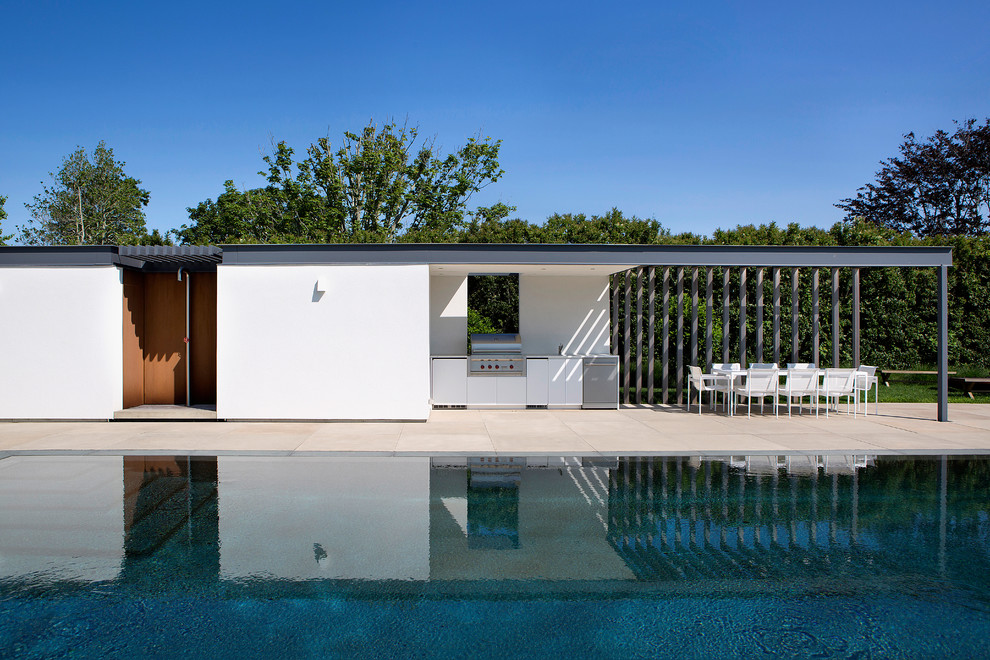 Esempio di un patio o portico moderno dietro casa con un tetto a sbalzo