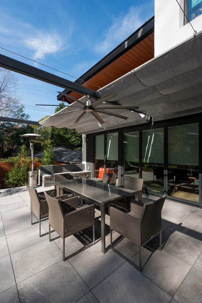 Idee per un patio o portico minimalista dietro casa con un parasole